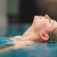Kühle den Körper, beruhige den Geist. Aufnahme einer jungen Frau, die sich im Pool entspannt.