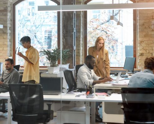 Gemeinsame Arbeit an einem Projekt. Eine Gruppe junger, gemischtrassiger Geschäftsleute arbeitet in einem kreativen Büro zusammen. Konzept zur Teambildung. Büroalltag