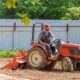 Bodenfräsen: Traktor mit angebauter Bodenfräse beim Fräsen eines Ackers