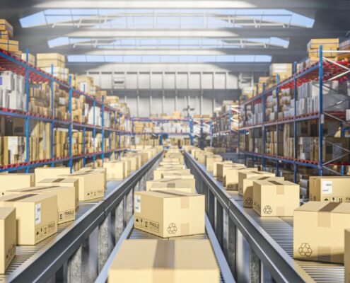 automatisiertes lagersystem mit paketen auf förderband in hell beleuchtetem industriegebäude