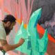 Graffiti Sprayer malt präzises Wandbild mit Pinsel