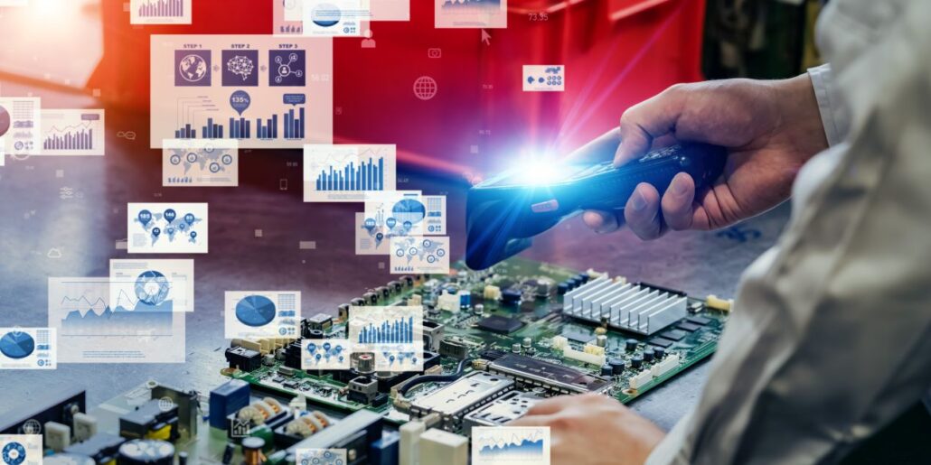 Hand scannt elektronische Platine, waehrend ein APS System digitale Analysen und Diagramme zur Fertigungsoptimierung anzeigt