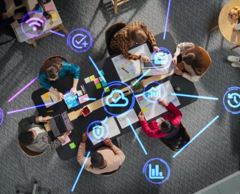 Team arbeitet gemeinsam an digitalen Projekten, vernetzt durch ein APS System mit Symbolen fuer Kommunikation und Effizienz