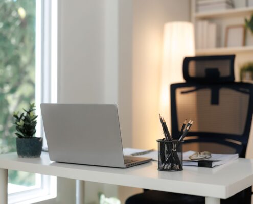 Moderner Bueroarbeitsplatz mit Laptop, Pflanzen und Notizbuch auf hellen Schreibtisch – Symbol fuer effizientes Arbeiten und faire BueroService Preise