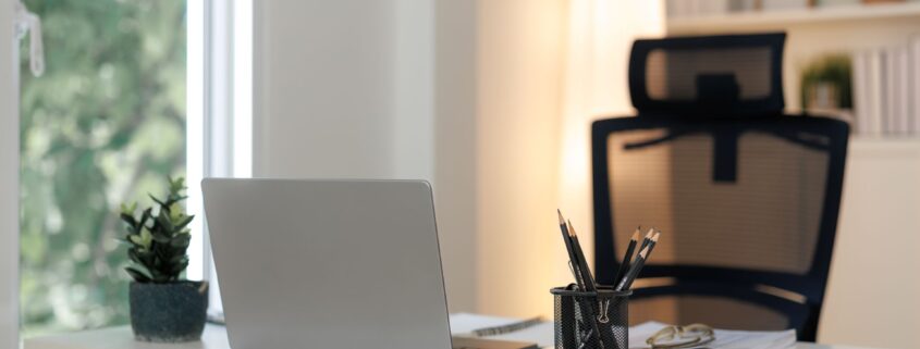 Moderner Bueroarbeitsplatz mit Laptop, Pflanzen und Notizbuch auf hellen Schreibtisch – Symbol fuer effizientes Arbeiten und faire BueroService Preise